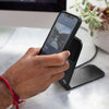 John about to mount his phone on a wireless charging stand