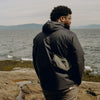 James wearing ultralight packing cube by the ocean