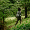 A guy walking with the cloud variant of ultralight packing cube